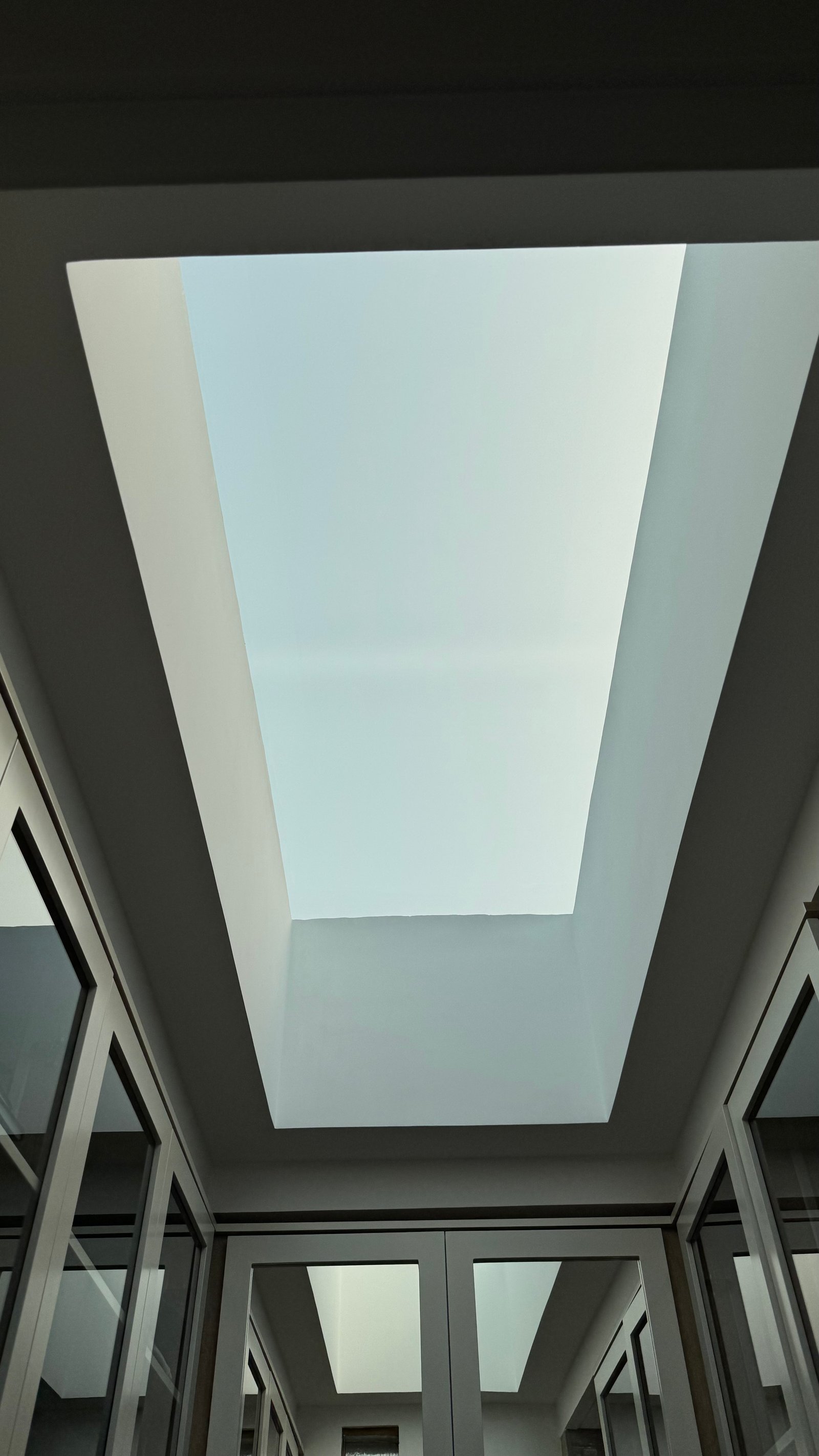 Pasillo moderno con claraboya central y ventanas de piso a techo — proyecto CASA MHN, por Hermann Arquitectos, en Nordelta